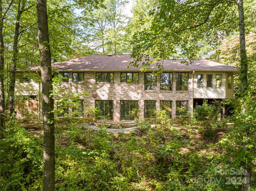 Opportunities abound on your own private wooded retreat of 7.48 acres, just a short 8-minute drive from the charming downtown of Black Mountain. This property boasts a spacious main home with three bedrooms and four full baths, offering comfort and serenity. Additional perks include both an attached and detached garage with a versatile workshop space for your hobbies and projects. An expansive outbuilding is also set on one of the parcels, ideal for storing your boat or RV, ensuring all your adventures are ready to begin at a moment's notice! This haven is a unique combination of four parcels, presenting endless possibilities for expansion or investment. As the seasons change, you'll be treated to enchanting winter views, while the lush, wooded surroundings provide the ultimate in privacy. This exceptional property is your ticket to serene mountain living without sacrificing the convenience of being minutes from the vibrant heart of Black Mountain.