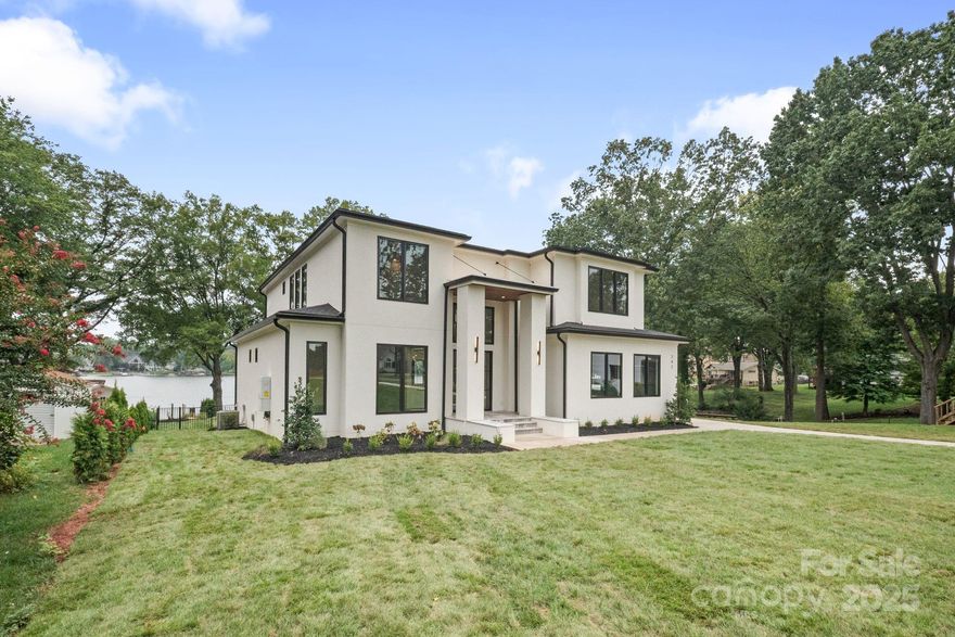 Exquisite modern architecture greets you at this newly built Lake Norman estate. Step inside to discover a dramatic foyer with a grand curved staircase, setting the tone for sophistication throughout. The expansive two-story living room captivates with spectacular lake views, flowing seamlessly to the chef's kitchen featuring an oversized sleek quartz island, top-tier appliances & abundant space for entertainment. Adjacent dining offers stunning lake & pool vistas, perfect for memorable gatherings. Experience outdoor living with a covered porch featuring a fireplace by the resort-style pool overlooking the water. The primary suite, accessed through elegant double doors & private hallway, boasts luxurious wall moldings & panoramic water views. Indulge in the spa-inspired ensuite w/ oversized walk-in shower & dual vanities. The generous bedrooms all showcase tranquil lake views. The new covered dock awaits your boating days ahead. ALMOST COMPLETE PHOTOS TO COME SOON.