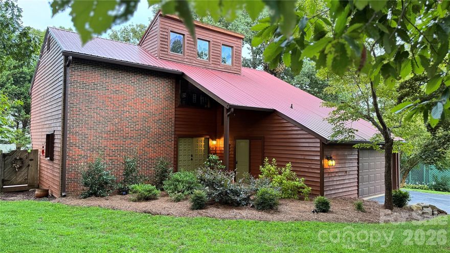 This remarkable custom-built home has been professionally and tastefully updated over the last few years and finds itself situated in a quiet, established neighborhood just minutes from I-85 and Hwy 74. The home offers a rare combination of privacy, character, exceptional amenities, and everyday convenience. Inside, you’ll find three generously sized bedrooms and two full bathrooms, with warm wood finishes and classic rustic details that give the home a comfortable, inviting feel. A wood-burning stove and towering ceiling anchor the main living area and create a cozy gathering space during the winter months. An in-ground swimming pool is surrounded by an expansive concrete deck, making it ideal for entertaining or relaxing on warm days. A poolside cabana with a half bath provides added convenience for guests, while the large deck overlooking the backyard is ideal for enjoying morning coffee, evening cookouts, or simply taking in the peaceful setting and mature trees. The home also offers an attached one-car garage with a utility room, mudroom, and additional upper storage, along with a detached shed for tools, hobbies, or seasonal storage. Exceptional landscaping design frames the property, enhancing its park-like atmosphere with year-round shade, color, and curb appeal. With no HOA, close proximity to Crowders Mountain State Park, and easy access to major highways, this home delivers a relaxed, nature-forward lifestyle without sacrificing location. It’s a place where you can unwind, entertain, and truly feel at home.