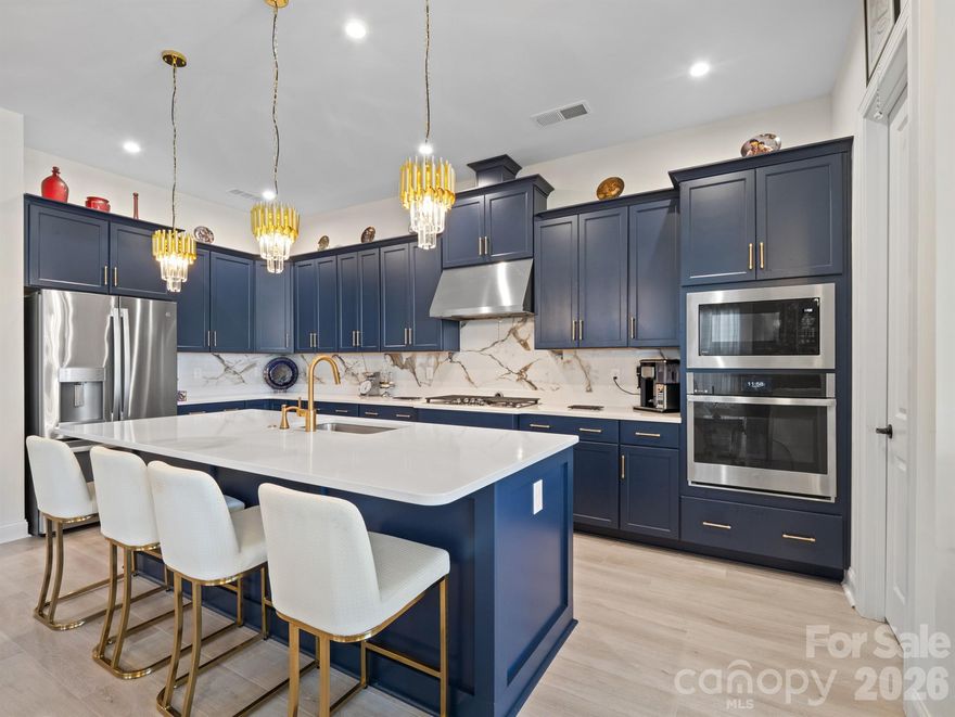 Beautiful and meticulously maintained, this stunning home offers designer finishes, spacious living areas, and access to resort-style amenities. A private office with elegant French doors provides the perfect space for working from home or quiet study. The chef’s kitchen is a true highlight, featuring a massive island with a one-bowl sink, 5-burner gas cooktop, wall oven, walk-in pantry, quartz countertops, and a porcelain marble backsplash—ideal for both everyday living and entertaining. Natural light pours into the sunroom, which extends off the living room to create a bright and airy space perfect for lounging or hosting guests. The primary bedroom suite is a peaceful retreat with dual vanities, a large tiled shower, and a custom closet organizer designed for optimal storage and convenience. Secondary bedrooms are spacious and thoughtfully designed. Bedroom 2 includes its own private bathroom, making it perfect for guests or as a mother-in-law suite. Bedroom 3 offers a generous walk-in closet, providing plenty of storage space. Throughout the home, stylish design elements such as tray ceiling accents, updated chandeliers, and 7.5 -inch luxury vinyl plank (LVP) flooring elevate the overall aesthetic. Large-format tile in wet areas adds both beauty and durability. The garage is equally impressive, featuring gleaming epoxy flooring and a utility sink for easy clean-up. This home is conveniently located near Village Commons, offering quick access to shopping, dining, and everyday essentials. As part of a vibrant community, residents can enjoy a full suite of resort-style amenities including a clubhouse, art studio, swimming pool, pickleball, bocce ball, and tennis courts. From its functional layout and thoughtful upgrades to its unbeatable location and lifestyle offerings, this home truly has it all. Don’t miss the opportunity to make it yours!