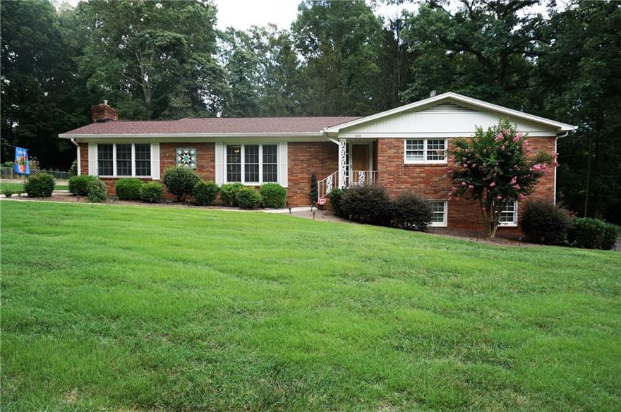 Room to Roam in this sprawling brick ranch. Gas HVAC 2015, Roof 2013, replacement windows. Large living space for entertaining. Neutral colors, wood floors and laminate wood floors. Kitchen features seated bar, gas range, tile backspash. Basement level host kitchen with tile floors and open Great Room area, full bath, & laundry. Bedroom/office  downstairs does not have a window. Ample parking w/ a 2 car attached carport, circular driveway around the back of the home. Patio outback to relax and view the level yard. Brick outbuilding for workshop or storage. Downstairs could used as an in-law suite if desired. Located just off I-40. Quick access to Hwy 16.  Desirable established development of Wilburn Hunsucker/Lecho Park.