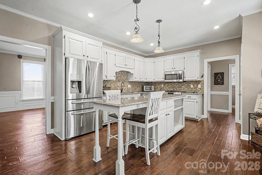 Tucked on nearly three tree-lined acres, this stately two-story brick home delivers the rare combination buyers dream about — estate-level privacy with quick access to town, schools, shopping, and major routes.
Step inside and you’ll find a main-level primary suite designed as a true retreat, complete with a spacious en-suite bath. The updated gourmet kitchen flows effortlessly into a sun-drenched sunroom — the warm, welcoming heart of the home. Just beyond, a bi-level deck with built-in grill invites you to entertain, unwind, and soak in peaceful wooded views.

Upstairs, three oversized bedrooms and two full baths offer plenty of room for family and guests. A dedicated media room with full theater setup, plus expansive bonus and flex rooms with a mini kitchen, mean there’s space for movie nights, hobbies, a home office, or multigenerational living.
Rich hardwood floors run throughout, and thoughtful design delivers storage galore — abundant closets, built-ins, and well-planned utility areas at every turn. A convenient side-entry two-car garage with drop zone keeps daily life organized.

Outside, beautifully landscaped grounds come alive each spring with dahlias, primroses, knockout roses, rose trees, daffodils, and hostas — your own private garden retreat just minutes from it all.
Acreage. Privacy. Convenience. This one truly has it all.