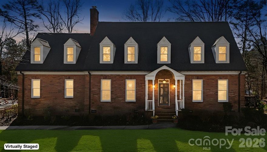 Nestled on nearly three serene, tree-lined acres, this stately two-story brick home offers an estate-like sense of privacy, exceptional space, and flexible living options. The main-level primary suite features a spacious en-suite bath, providing a private and relaxing retreat. An updated gourmet kitchen opens to a cheerful sunroom, creating a bright, welcoming space at the heart of the home.

Just beyond the sunroom, a bi-level deck extends into the natural setting and features a built-in grill—perfect for outdoor entertaining while enjoying peaceful wooded views.

Upstairs, three oversized bedrooms and two full baths provide comfort and convenience for family or guests. 

Rich hardwood floors flow throughout, while thoughtful design offers storage galore with abundant closets, built-ins, and well-planned utility areas throughout the home. The main level also includes a convenien side entry two-car garage with drop zone and spacious living areas designed for effortless entertaining.

Additional highlights include a dedicated media room with full theater setup, expansive bonus and flex rooms with a mini kitchen, and beautifully landscaped grounds that come alive each spring with dahlias, primroses, knockout roses, rose trees, daffodils, and hostas.