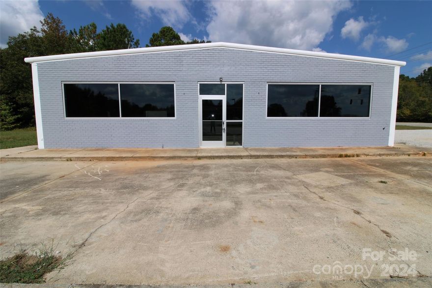Great commercial lot on the corner of two State-Maintained Highways!  This corner is just outside of Rock Hill in a highly traveled area with a traffic signal.  Property is very level and currently has entrances from both cross roads. Easy access in and out of the parking lot and very visible from the road. Plenty of parking area. Interior of building is large and open making it easily adaptable to many uses. Building has a new roof and new exterior paint.  Building and land are being sold in as is condition.