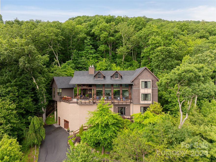 Escape to a living masterpiece! Custom designed and recently renovated, this home is inspired by its natural surroundings and offers exceptional, layered mountain views. Every detail has been thoughtfully considered offering the finest materials and finishes, from the stunning wood floors and custom built-ins to the floor-to-ceiling windows. The extravagant kitchen flows into an open dining area that overlooks the inviting great room, adorned with beams and a majestic pebbledash fireplace, blending harmoniously with the oversized outdoor living. Off the porch, a private office with a half bathroom offers a secluded workspace. The main level owner's suite is a true retreat, boasting views and an spa-like bath. Upstairs, you'll find 2 bedrooms with a shared bath, while the basement level provides ample space for guests with a separate family room and an additional bedroom and bath. This home is a sanctuary of elegance and comfort,perfect for those who appreciate the finer things in life.