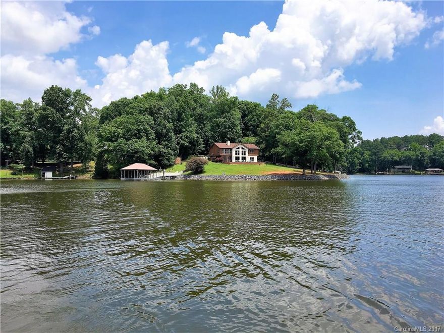Beautiful waterfront home offering panoramic views with over 400 feet of shoreline. Home oversees the peninsula and features 3 BR and 2.5 baths. Open floor plan with two stone fireplaces. Master has great views, sitting area and remodeled bath with rain shower. Large kitchen has center island cooktop, granite counters and loads of cabinet space. Covered metal floating dock with vinyl rails and 2 jet ski lifts. Lake life just minutes from dining/shopping and a short drive to Uptown. Opportunity!
