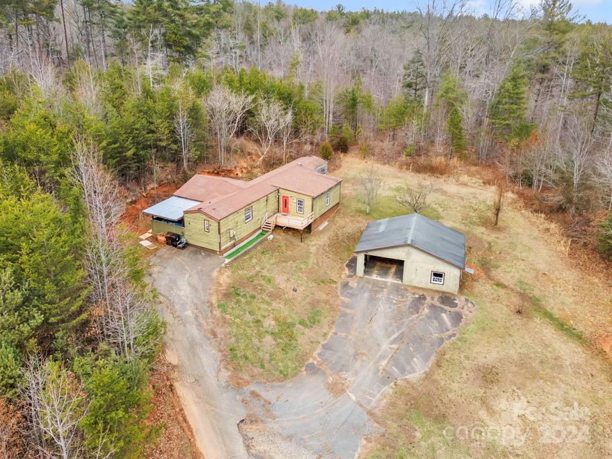 Rare Opportunity in the heart of Western North Carolina! LARGE 4BR/2BA home with just over 5 acres of land and plenty of privacy! This property is located minutes from Lake James and has much to offer. You'll have a nice cabin style feel with a covered back deck and a large detached garage, fruit trees and a stream on the back end of the property. Solitude and seclusion with plenty of room to modify and make it your own.  This home will not qualify for financing.