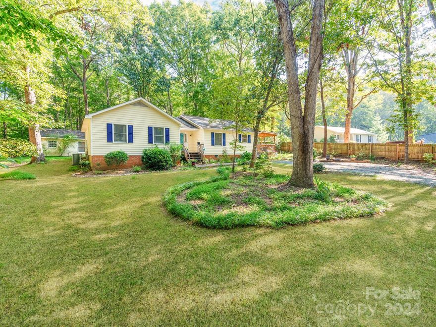 Welcome to this charming 3-bedroom, 2-bath home nestled in the picturesque town of Waxhaw, NC. investors dream or first time buyers perfect home. Surrounded by mature trees and lush landscaping, this property offers a serene and private retreat. The open floor plan creates a seamless flow throughout the living spaces, with a cozy living room featuring a stunning fireplace that serves as the room's centerpiece. The kitchen, while compact, is inviting and perfect for daily living. Step outside to the expansive covered deck, which provides a delightful vantage point to enjoy the beautifully landscaped side and backyard. Additionally, the lot includes two practical storage buildings, enhancing the home's functionality and appeal.