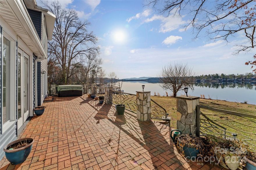 Discover lakeside living in this stunning waterfront property. Nestled on a private one-acre level lot, this home offers breathtaking long-range views & unforgettable sunrises over Lake James. Featuring 3 spacious bedrooms & 3.5 bathrooms, with 2 primary suites, catering to both comfort & privacy. With over 3800sf, there is ample space for relaxation and entertainment. The interior boasts hardwood floors throughout. The billiard room, bar area and expansive brick patio overlooking the lake offer perfect settings for gatherings of all sizes. Outdoor enthusiasts will delight in the property's direct waterfront access, PRIVATE boat ramp and covered dock with large seating area. The solar panels ensure energy efficiency without compromising on comfort. The property includes a generous 3-car garage & 2-car covered parking, accommodating cars, RVs and watercraft alike. No HOA and short-term rentals are allowed.  Enjoy solitude in this quiet location just off main channel.