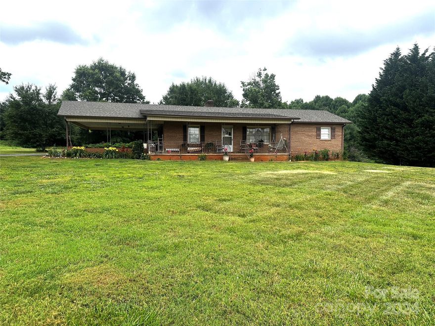 Discover the perfect blend of classic charm and expansive country living with this brick ranch home, built in 1974, in Alexander County, NC. The residence offers 3 bedrooms, 3 baths, and an updated kitchen with granite countertops. The full basement provides extra storage or workshop space. A 2 car carport. Situated on a 31+/- acre property with wooded and cleared areas, and a tranquil creek, the estate offers a picturesque setting for outdoor activities. With over 900 feet of road frontage, accessibility is seamless. The property includes two older chicken houses, offering agricultural potential. The seller requests lifetime rights, providing a unique stewardship opportunity. Contact the listing agent for more information.