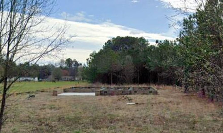 Building lot with an existing foundation for a 2,055 sq ft home.