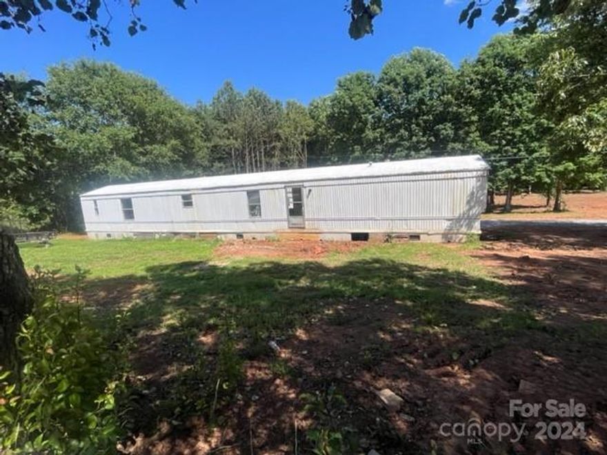 unrestricted land in the Cliffside community conveniently located in southern Rutherford County. Older mobile home on the lot could be livable with some work or remove it and bring your mobile home, modular home, tiny home, stick built home or Rv. Recent survey on file and lines recently marked. Cash only sale.