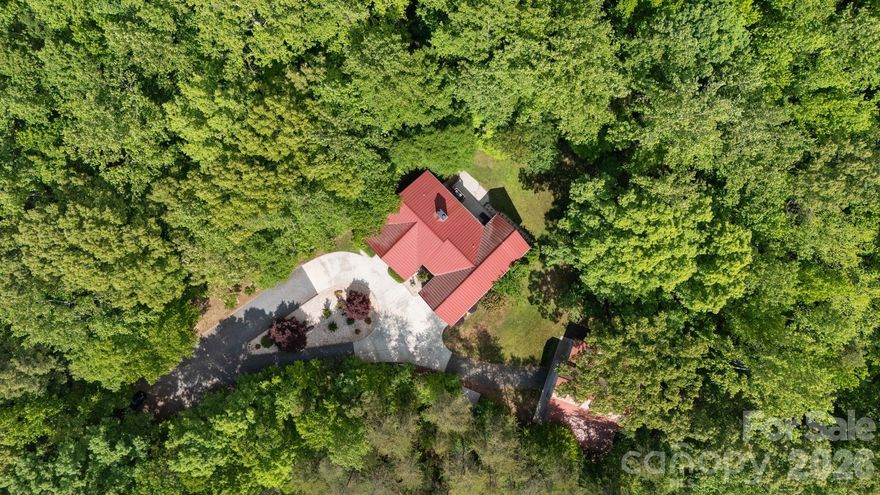 A RARE opportunity to own a private country estate on nearly 8 acres featuring PROTECTED LAND around your estate giving you unmatched PRIVACY, peace pace but close to conveniences and top-rated schools, and land curated amenities—from trails, axe-throwing, parking lot, guest parking area, circular entrance with TWO DRIVEWAYS (rarity!!!) & usability of acreage that's TURN KEY. 

Built in 2014, this custom home offers exceptional craftsmanship, much of which was curated from the land itself....truly one-of-a-kind that is an EXPERIENCE to see!

This property is designed for both everyday luxury living to feel peace without sacrificing being too far away from everything.You CAN have it all at this RETREAT. Newly updated kitchen, tankless hot water heater, and a basement to impress with a: movie area, kitchen, game room, exercise room with sauna, office, and flex room being used as a 4th BEDROOM, and a utility room with an added sink....every room has been purposefully designed. 

Do not miss the CHARACTER this home speaks indoors and outdoors!

Land complete with: 
so many trails, a sports field, fire pit, zipline, tree fort, swing, axe throwing area, parking lot, and a oversized barn with 14 ft doors to accommodate an RV or boat—creating a unique, resort-style experience right in your own backyard. 

Entry to property: 
featuring TWO separate entry points/driveways—an incredibly RARE and highly desirable feature that is very hard to get approved; along with ample parking spaces.

Basement Level:
Designed for entertainment and function, the lower level features a theatre area, gym, bar, kitchenette, two additional rooms, a full bath(built for a shelter), gas fireplace, and a mechanical room equipped with a tankless gas water heater and utility sink. Enjoy direct access to a covered patio, perfect for relaxing outdoors with string lights and speakers to enjoy your endless view whether its the wilderness or your large party or event outdoors.

Main Level:
The main level features an open and inviting layout with a vaulted ceiling living room and gas fireplace, spacious dining area, and a beautifully UPDATED kitchen equipped with a gas cooktop, pot filler, oversized commercial-grade refrigerator and freezer, dual sinks, large island with seating, extra prep sink, and a walk-in pantry with built-ins. 

The primary suite offers a private retreat with a full bathroom, walk-in luxury shower, and two separate walk-in closets. The primary suite wakes you up to sunrise through the windows that make you feel like you are in the trees. It's a pure escape and retreat! Two additional bedrooms are also located on the main level, each with access to their own full bathrooms on the opposite side of the house as the primary. 

Additional highlights include a mudroom, laundry room with sink, half bath, and an oversized 2-car garage with vaulted ceiling and the third floor flex room used as a bonus/yoga room.

Enjoy outdoor living with both a covered wide front porch and a covered rear porch with stairs down to the back patio connected to the basement back door and entertainment space; perfect for taking in the peaceful surroundings or having a lavish party.

The property also includes: a 2-car attached garage PLUS an approximately 1,800 SF detached 6-car garage/workshop with 14’ doors, ideal for RV or boat storage, hobbies, or additional workspace. HIGH SPEED INTERNET, 400A electrical to home and 1G internet. 60 YEAR METAL ROOF. 

Despite its private setting, the home is conveniently located just 4 miles from shopping and dining, including Lowe’s, Publix, and Walmart, 7 minutes to the Clover Recreation Center, and approximately 30 minutes to Charlotte Douglas International Airport, all within the award-winning Clover School District.