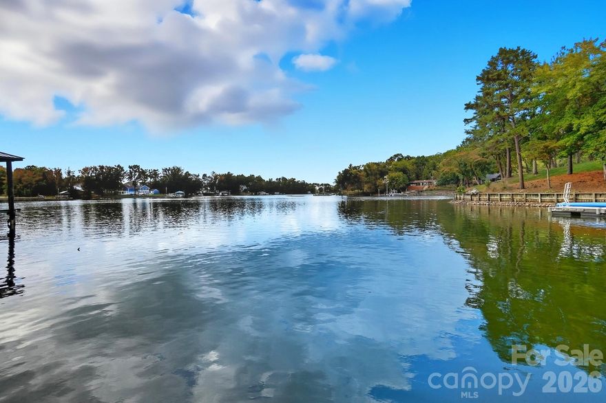 Live the Lake Life Every Day! This stunning waterfront home on Lake Wylie offers the ultimate in relaxed luxury and scenic beauty. Step outside to enjoy a massive deck, covered patio, and floating dock—perfect for entertaining or simply soaking in the peaceful lake views. Surrounded by beautiful trees and natural shoreline, this serene setting is your personal retreat. Inside, an open-concept floor plan welcomes you with soaring ceilings and abundant natural light pouring through oversized windows. The heart of the home is the gourmet kitchen, featuring stainless steel appliances, a center island, granite countertops, and a spacious dining area that flows seamlessly into the vaulted great room, creating the perfect space for daily living. A dedicated Home Office with wainscoting offers a quiet, elegant space for working from home. The main-level primary suite is a showstopper, offering lake views, dual vanities, a large tiled shower, and  custom walk-in closet. The upper level features three bedrooms, two full baths, and a versatile loft, providing ample space for family and guests. The lower level is designed for ultimate entertainment, boasting a massive Rec Room ready for gatherings. An expansive unfinished area awaits your personal finishing touches, providing incredible potential for a 5th bedroom, 4th full bath, home gym, media room, or extra storage. This is more than a home; it's a seamless blend of luxury living and perpetual lakeside relaxation.