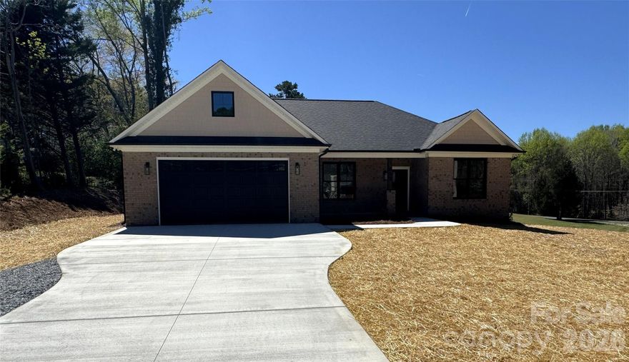 This beautifully crafted new construction home exudes quality and attention to detail throughout. Inside, luxury vinyl plank flooring runs seamlessly throughout the home, offering durability, low maintenance, and modern style. Black fixtures accent each space, providing a sleek and cohesive look while the open, split floor plan creates an easy flow between living spaces. Adorned with tray ceilings in both the living room and primary bedroom, adds yet another level of quality and design. The kitchen is the heart of the home offering a spacious island and breakfast bar, accented with pendant lighting, quartz counter tops, a tile backsplash and is complete with a deep farm sink and soft close cabinetry while the primary suite features a massive walk-in closet and a charming barn door that leads into the primary bath where you’ll find dual sinks and a custom tile shower. Step outside to the 12' by 22' covered back patio — perfect for relaxing or entertaining, no matter the season. In addition, the home also offers 144 square feet of attic space, providing plenty of extra storage!