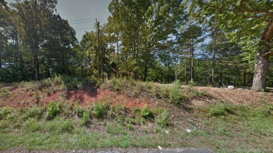 Beautiful lot with large hardwood trees. Over 1.65 acres. Convenient to Charlotte, shopping, airport. Sold as lot only. No value given to house on lot.  As is, no repairs to be made.  Currently has well and septic, but city water and sewer available.  Buyer to verify water and sewer.