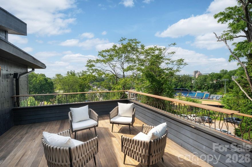 Stunning urban retreat in the heart of Asheville, just steps from historic McCormick Field & easy walking distance to downtown and the vibrant South Slope. Thoughtfully designed with high-end finishes throughout, this striking 3-story home offers abundant natural light & flow throughout. Large sliding windows and doors open to the outdoors, seamlessly blending indoor & outdoor living. All bedrooms enjoy views of the mountains & city skyline. Enjoy an oversized outdoor shower on the second level—a perfect spa-like touch. On the third level, a spacious loft & crow’s nest deck overlook McCormick Field, offering a front-row seat to Asheville Tourists baseball games. Additional highlights include a generous fenced backyard, a large Ipe back deck with fireplace & grilling area, a sunken private hot tub, and plenty of storage—including a gear room adjacent to the garage. This serene modern sanctuary offers an exceptional home base for enjoying all of Asheville.