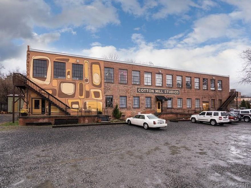 Rare opportunity in the heart of the River Arts District to own a high profile & iconic income-producing property. The Cotton Mill Studios has two floors of fully tenanted space, currently configured into 8 units (metered separately for electric). This solid and updated commercial building offers investment potential with upper-level river views, natural light, beautiful flooring and off-street parking. Basement with potential storage capacity & two loading docks.