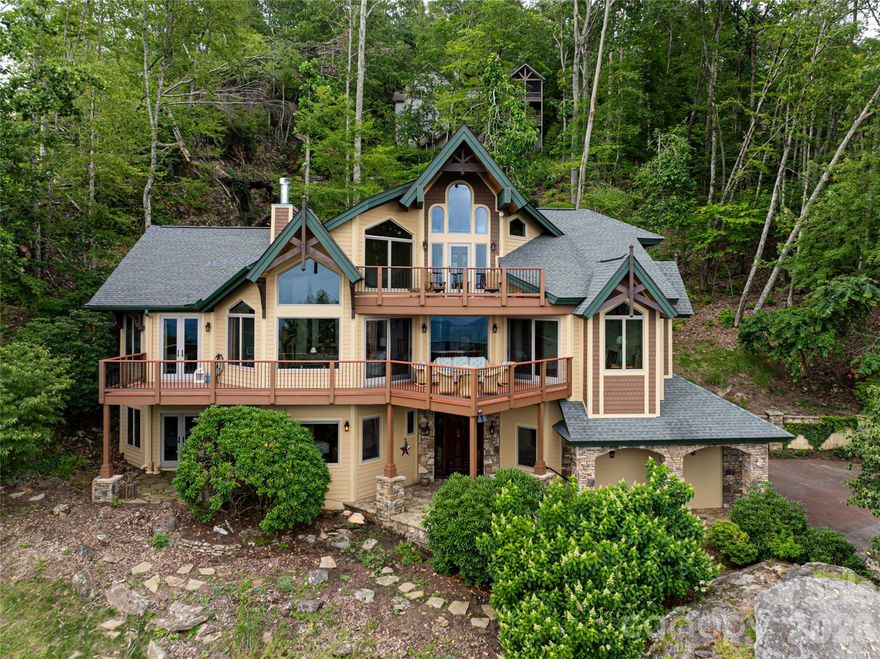 Rustic mountain character meets refined European influence in this architecturally inspired Mountain Air retreat, where strength, elegance and panoramic views converge. A monumental boulder in the front landscape creates a dramatic arrival, setting the tone for the extraordinary design within. Inside, a soaring three-story foyer filled with natural light delivers an immediate sense of scale and grandeur. The entry level offers two private guest suites, providing comfort and seclusion for family and friends, while a curved staircase and private lift connect each level with effortless grace. The main living level centers on a magnificent great room anchored by a grand stone fireplace and framed by walls of windows that capture ever-changing mountain vistas. Soaring ceilings enhance the sense of openness, while the adjoining dining area and chef’s kitchen, appointed with expansive counters and refined finishes, create an ideal setting for intimate meals and elegant entertaining. The primary suite is a sanctuary, featuring its fireplace, private deck and a spa-inspired bath designed for renewal. An upper-level loft offers flexible space for a studio, office or additional bedroom. Beyond the home, Mountain Air residents enjoy miles of trails, resort-style amenities and rare luxury of a private airport. This is a residence of distinction, where inspired design and mountain beauty create an exceptional way of life.