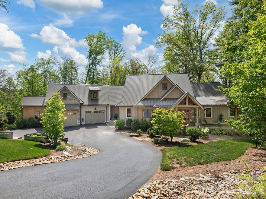 Nestled on more than two private, wooded acres, this custom contemporary farmhouse is a refined mountain retreat, offering a rare balance of elevated design, privacy, and versatility within Sovereign Oaks—one of Asheville's most coveted and active luxury developments.

Spanning nearly 4,000 square feet, the 4-bedroom, 4.5-bath residence (including Guest Suite) is thoughtfully designed to live expansively while maintaining an intimate, grounded feel. A fully appointed guest suite above the garage—complete with its own living area, bedroom, and bath—provides a private haven for visitors, executive office space, or a secluded retreat. For the collector or enthusiast, the property is exceptionally equipped with a 1,000-square-foot RV garage, an oversized primary garage, and an additional utility garage/workshop—uncommon offerings that elevate both function and lifestyle.

Inside, the home unfolds with warmth and architectural intention. A living room framed with Cyprus timber beams and anchored by a high-efficiency stone fireplace flows seamlessly into a chef’s kitchen designed for both everyday living and intentional entertaining. Appointed with a Thermador oven and range, quartzite countertops, high-end cabinetry, and a concealed wet pantry tucked behind a herringbone brick wall, the kitchen is as sophisticated as it is functional. The generous island invites gathering, while the space transitions effortlessly to the dining area, living room, or out to the covered deck with outdoor fireplace and built-in grill.

The main-level primary suite is a true sanctuary, featuring radiant heated floors, a soaking tub, and a spacious custom walk-in closet designed with intention and ease. The lower level offers a second ensuite bedroom with dual walk-in closets and a third bedroom with its own bath, framing a central living space that opens to a covered patio and private woodland backdrop.

The landscaping is both curated and understated, creating a low-maintenance, park-like setting. The RV garage is discreetly positioned at the rear of the property with separate access and utilites. Winter mountain views, exceptional seclusion, and a gently sloped backyard—currently a soccer practice area with potential for a putting green—complete the outdoor experience.

Please refer to the features sheet for additional details.