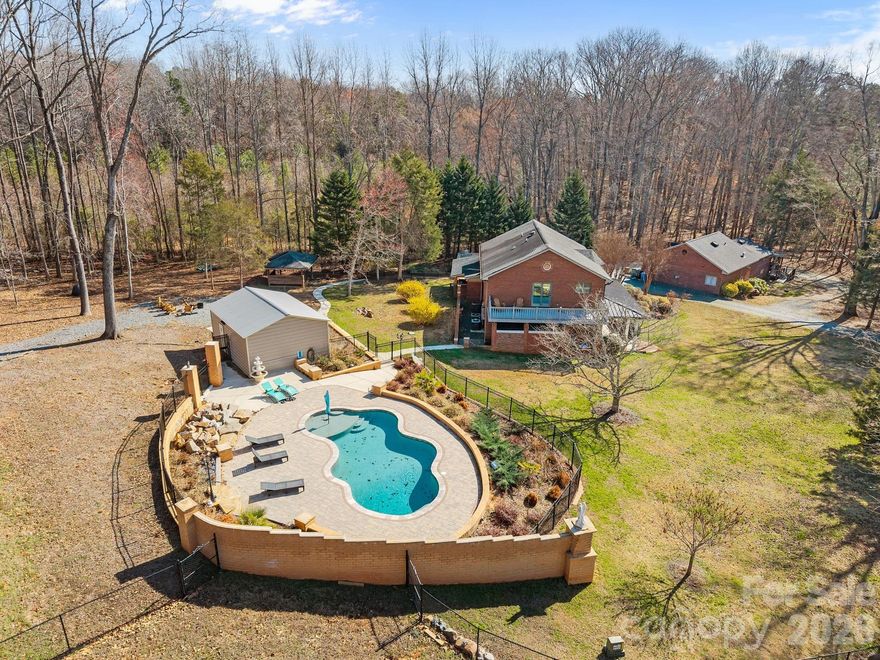 Welcome to 10436 Connell Rd. A  private 4.89-acre gated estate featuring a main residence, guest house, and resort-style amenities. This rare property offers exceptional privacy with mature trees, open grounds, and multiple outdoor living areas. The main home includes a bright, flowing layout and a second-floor terrace overlooking the estate. A separate guest house with its own porch provides ideal space for visitors or multi-generational living. Enjoy a private in-ground pool, expansive lawn, and endless potential across nearly five acres. A true hidden oasis at 10436 Connell Rd.