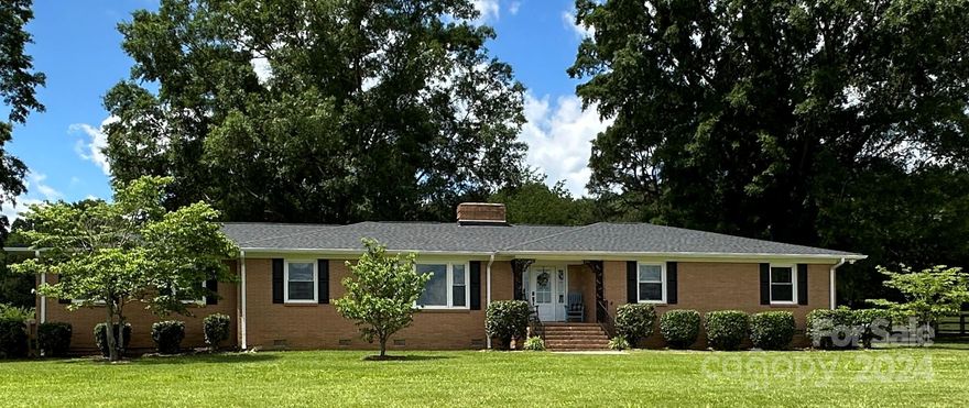 LOOK NO FURTHER! This is the gem you have been looking for! This all brick, 1 story home has 3 bedrooms, 2 baths and sits on 3.10 acres. Move in ready with stellar renovations in kitchen and bathrooms while keeping just a hint of that retro charm! New cabinets, quartz countertops, backsplash, appliances, fixtures, flooring, paint, etc. This is the kind of home that doesn't just whisper, it shouts comfort, privacy and style! With such a beautiful setup and only a stone's throw from downtown, it's like having the best of both worlds. New roof in 2020. Parking for guests in front & fenced backyard w/electric gate takes you to enjoy your private retreat. Beautiful backyard w/apple trees, flowers, and more acreage behind for a garden or other activities. 2 car carport w/large storage/workshop. Detached 1 car garage/workshop in need of repairs & AS-IS. 2 fireplaces in home are disconnected, also AS-IS. Don't wait. Come see ASAP. You will not be disappointed and may just find your new home.