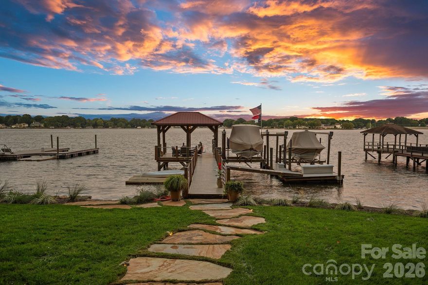 A one of a kind waterfront estate on Lake Norman, fully transformed through a renovation completed in 2025. Perfectly positioned on a one-acre, tree-filled lot in a private neighborhood with resort-style amenities, this home combines timeless elegance with modern luxury. Walls of glass and expansive sliding doors frame sweeping big water views and breathtaking sunrises, while rare deep water at the double slip dock allows for swimming and diving right from your backyard.

The thoughtfully designed interior balances warmth and sophistication, anchored by a soaring two-story natural stone fireplace, wide-plank Caribbean floors, and designer finishes throughout. A first-floor primary suite offers a private balcony with panoramic views, spa-inspired bath with heated marble floors, custom shower, and a spacious walk-in closet/changing room. The chef’s kitchen features an expansive island, Sub-Zero refrigerator, scullery with custom pantry, and adjacent lounge with wine fridge. A lake-level retreat includes a second kitchen, bourbon room, game room, and direct walk-out to a flagstone terrace with stone fireplace. Enjoy year-round living from the serene screened porch with hurricane shutters, or stroll past the koi pond and waterfall stream to your private dock with covered entertaining area, a high-powered boat lift, floating dock, and jet ski dock.

The grounds are truly a rare offering on Lake Norman - professionally designed with both beauty and livability in mind. Lush, layered landscaping blends mature trees, manicured lawns, and thoughtfully placed stonework to create both beauty and privacy. Expansive, usable yard space is a rarity on the lake, offering room to entertain, relax, or simply take in the water views from multiple vantage points. From the winding paths and tranquil water features to the seamless connection between indoor and outdoor living, every element of the landscape was intentionally designed to elevate the experience of lakefront living.

Every detail has been updated - hardboard siding, new roof, windows, HVAC systems, exterior stonework, custom lighting, irrigation, and professionally designed landscaping. The neighborhood enhances the lifestyle with a private beach, boat launch, pool, tennis/pickleball court and basketball court. Ideally located just minutes to shops, dining, and top schools, and less than 20 minutes to Uptown Charlotte and Charlotte Douglas International Airport, this estate offers an unrivaled blend of luxury, privacy, and convenience.  This is more than a home - it’s a lifestyle.