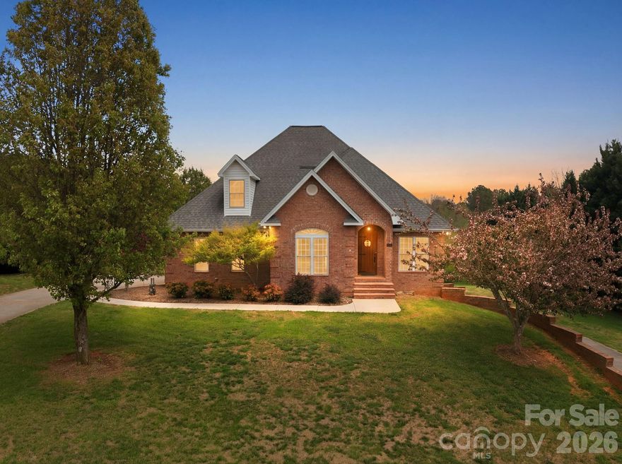 Beautifully appointed brick home offering spacious and thoughtfully designed living across multiple levels, including a basement and upper level. The home features a primary suite on the main level with additional bedrooms upstairs, providing enhanced privacy and flexibility. Situated on approximately half an acre, the property captures scenic views of the lake and surrounding mountains, creating a peaceful and inviting setting. The home includes multiple garage spaces with an upper-level 2-car garage and an expansive lower-level garage ideal for additional vehicles, workshop space, or storage. Located in a desirable subdivision, this home offers a perfect balance of comfort, functionality, and natural beauty.