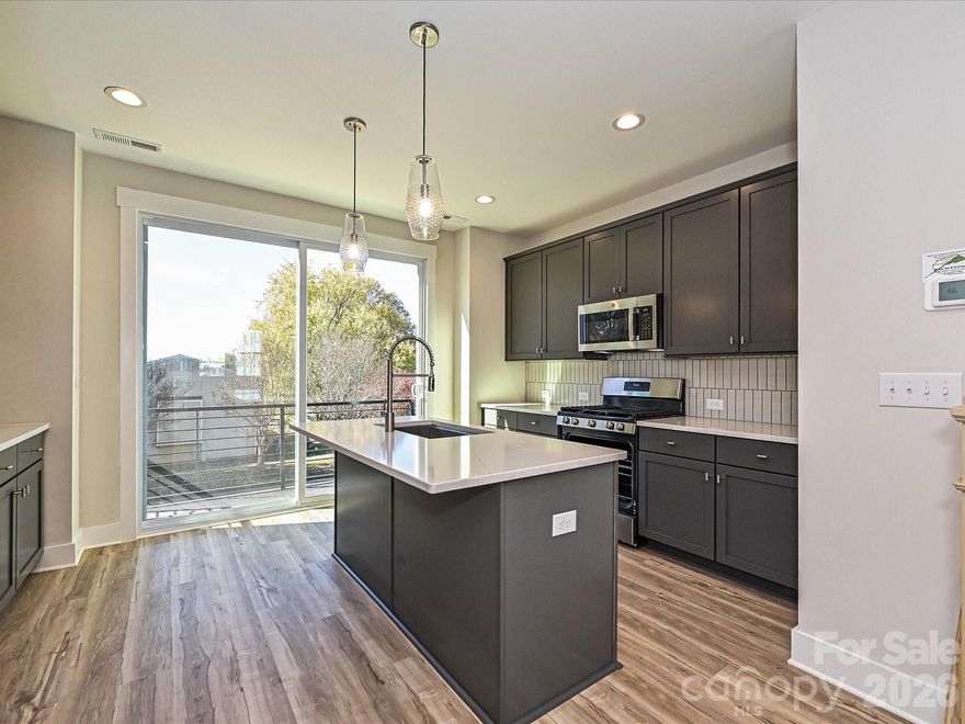 Versatile 4-story townhome with top floor Rec room & rooftop terrace, plus 1st floor Flex room with powder. A small deck off the kitchen offers seasonal city skyline views! Open layout of the 2nd floor makes gatherings a snap, or walk across the street to Camp North End. Kitchen features 42" cabs with quartz counters, backsplash, under-cabinet lights, trash pullout, pantry, & GE SS appliances with gas range, plus large undermount SS sink. 3rd floor has laundry plus 2 bedrooms & hall bath, which has quartz counters & tiled floor. Premier Bath has quartz counters, tiled floors, & tiled shower with semi-frameless glass. LVP floors are throughout the 1st & 2nd floors, plus 3rd floor hallway, with tile in 1st floor half bath & laundry closet. Oak treads are on all stairs. 9' ceilings throughout; 1-car garage plus driveway; on-street parking is available. Enjoy living minutes from Uptown Charlotte.