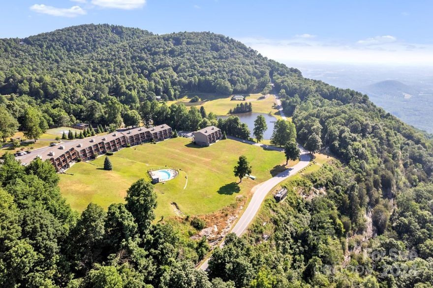 VIEWS For Days! One-Level Living Condominium w/ Majestic Long-Range Views! Welcome to your dream getaway,  
a stunning condominium perched atop White Oak Mountain.  Enjoy the open floor plan living room, dining area & kitchen that is designed to highlight the awe-inspiring long range views. Kitchen features GE appliances & gorgeous granite countertops & all floors are an upgraded beautiful slate tile that continues outside onto the private terrace. The primary suite includes an en-suite bathroom & access to a private terrace, where you can enjoy your morning coffee, overlooking the pool.  The living room has beautiful fireplace & built-in bookshelves that add warmth & charm, perfect for cozy nights at home. While enjoying the mountain life, you’re still just a short drive away from quaint towns w/dining, shopping, & cultural attractions. This condominium is a serene setting & is perfect for those seeking a hassle-free home in an idyllic mountain top location.