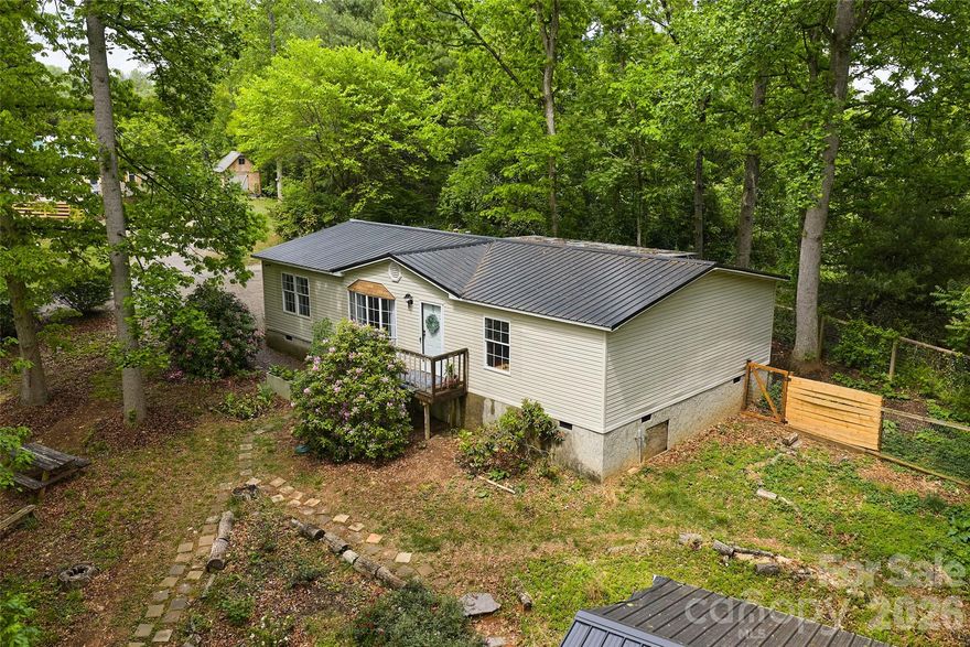 Come find this sweet retreat on a naturalized .78-acre parcel bordered by acres of woodland for peace, privacy and the rugged beauty of the Blue Ridge Mountains - very near the scenic drive/cycle route of The Farm Heritage Trail,  Addison Farms Vineyard, Hope for Horses Sanctuary, Timber Hall Event Venue and only 16 miles from Asheville. Cultivate your sustainable lifestyle in this very well maintained 3 bed/2 bath home with split bedroom layout, brightly renovated kitchen and baths, whole house water filter,  2024 upgraded well pump, 2026 HVAC , metal roof and other mindful improvements that will allow you to focus less on "have to" and more on "want to"! Enjoy the tranquil woodland vista from a spacious, covered grilling deck (grill conveys) with a safely fenced adjacent area and a garden shed for life's toys and tools. For more ambitious projects, the fully powered utility workshop/garage with insulated storage room also includes a second fridge, oven, freezer and storage racks for useful possibilities limited only by your creativity.  So if you've had enough of the madding crowd, leave the chaos behind - come immerse yourself in the quietly natural inspiration of Turkey Creek Terrace.