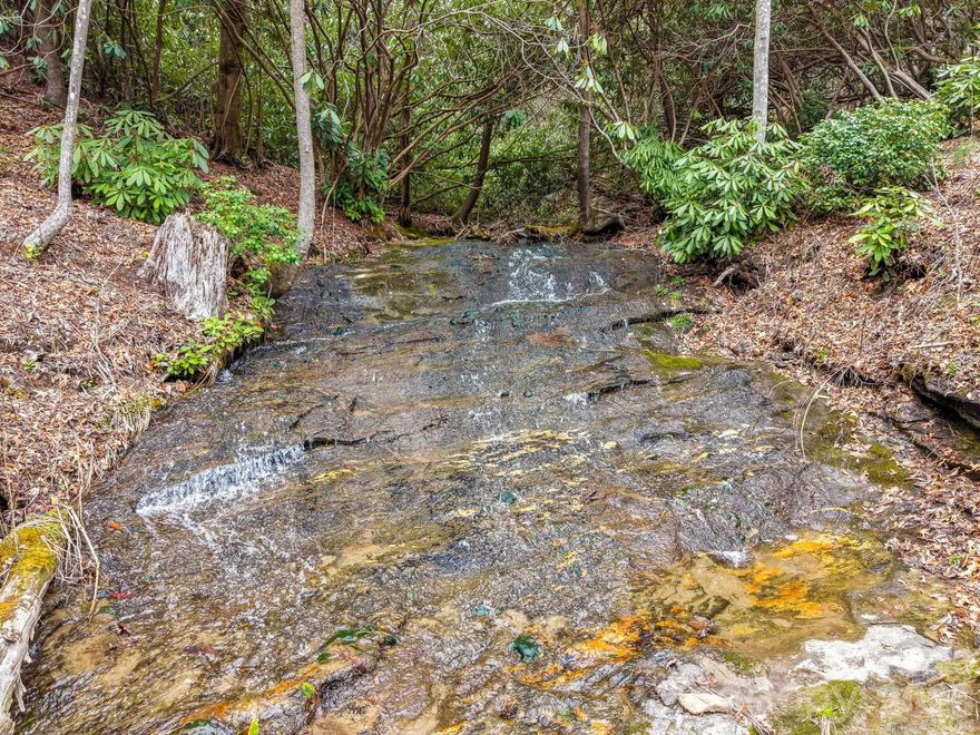 This gently sloping property situated in the Big Ridge Community near Cashers is a "must see". Ten+ unrestricted acres are cleared with some trees. Seller made multiple improvements since purchasing. Multiple house sites available with mountain views and sounds from the stream which runs through the property. You could possess your own waterfall with this property.  Perfect for a single home, small farm, or an estate.  This property offers privacy and solitude.  Only a few miles from Cashiers, Glenville Lake, outdoor recreation, and boutique shopping, you can get everywhere from here. The seller believes this property is unique, and someone who appreciates the beauty, culture, and opportunities of the region is the right fit for this property. Bring an offer!