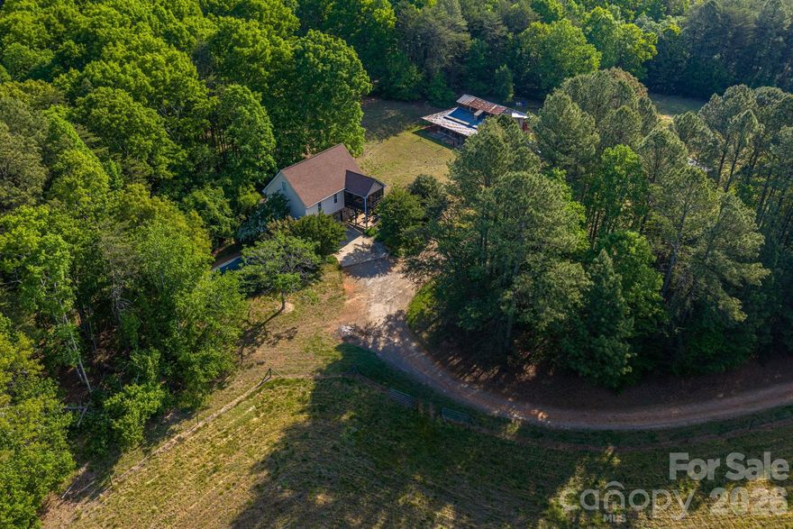 If You’re Looking for Peace and Quiet, This Is It!  Welcome to 10.58 beautiful acres in Western Lincoln County offering privacy, functionality, and room to breathe. This fully fenced property is ideal for horses or livestock, featuring two separate pasture areas and a 5-stall barn complete with a tack room and hay loft. The privacy here is exceptional, creating the perfect setting for a peaceful country lifestyle.  The home offers three bedrooms and two full baths with a comfortable layout designed for everyday living. A spacious den provides a welcoming gathering space, while the second-level screened porch allows you to enjoy the outdoors year-round without the bugs. Additional outdoor features include a rear patio and a swimming pool—perfect for relaxing or entertaining.  A two-car garage adds convenience and storage. This property also presents a great opportunity for buyers looking to add their own personal touches and updates—creating the perfect private retreat, mini-farm, or equestrian estate.  Located just minutes from Hwy 27 and near Cherryville, you’ll enjoy easy access to local shops, dining, and community events while still maintaining a peaceful rural setting. Outdoor enthusiasts will appreciate proximity to South Mountains State Park, offering hiking, horseback riding, and scenic trails. Convenient access to Lincolnton provides additional shopping, dining, and everyday amenities, while nearby highway access allows for an easy commute to surrounding areas.  Come experience the space, privacy, and potential this unique property has to offer!
