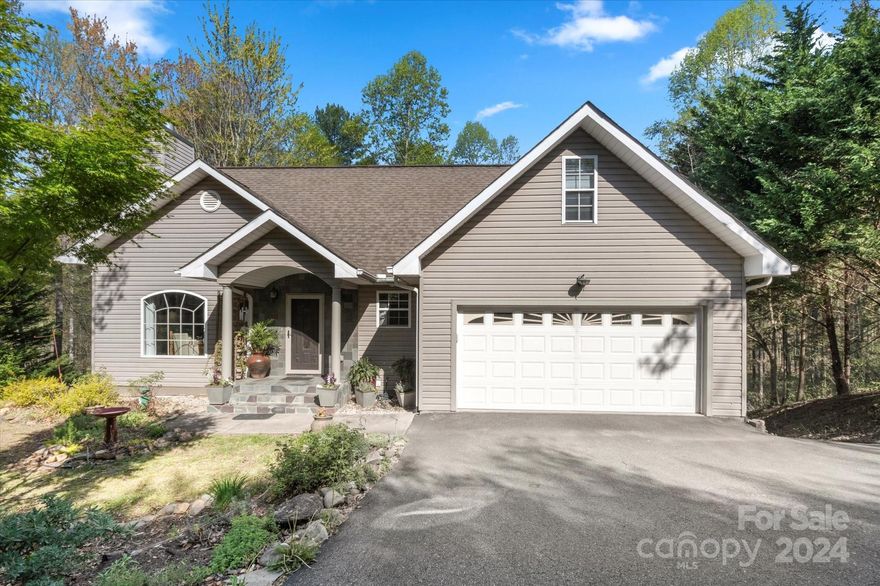 Aptly named Leisure Loop, this home sits at the end of a quiet culdesac in Weaverville. Enjoy the serenity of the wooded glen from the covered back porch of this beautiful home. Foyer opens to living room with vaulted ceilings and wood burning fireplace for cozy evenings. Recently remodeled kitchen has large island, electric cooktop with stainless steel hood and farmhouse sink, and opens to dedicated dining room. Newly updated primary suite on main level boasts bathroom with walk-in tiled shower and soaking tub, and walk-in closet. Upstairs has loft perfect for reading nook, large den, office, 2 bedrooms and full bathroom. Heated art studio with tray ceiling and large windows in basement could be converted to family/game room; has concrete floor currently. Two separate garages plus additional storage rooms allow for abundant space for projects and hobbies. New hot water heater & well pressure tank. Just 2 miles from Main Street shops and restaurants, 1 mile to I-26 Monticello Rd exit.