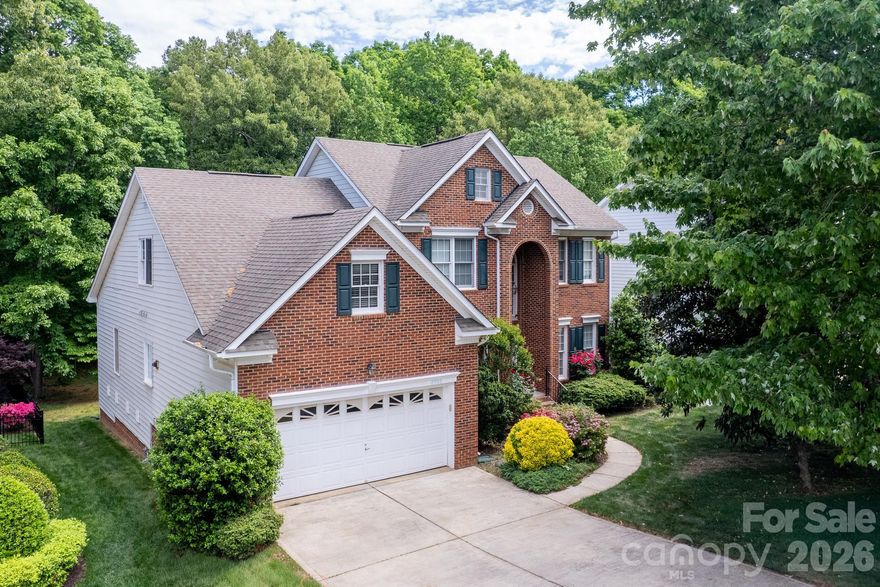 Immaculate, true 5-bedroom brick-front home in the heart of Ballantyne, featuring a highly sought-after main-level primary suite, a spacious 2-car garage, and a large, flat, private backyard backing to mature trees—offering the perfect setting for a future pool or outdoor retreat.

The main level welcomes you with a light-filled two-story foyer, elegant formal living and dining rooms with decorative molding, and a stunning two-story family room with a gas fireplace. Beautiful Brazilian hardwood floors add warmth and sophistication throughout the main living areas.

The updated white kitchen is both stylish and functional, complete with granite countertops, abundant cabinetry, and a spacious breakfast nook surrounded by windows. Enjoy seamless indoor-outdoor living with direct access to the deck—ideal for entertaining or relaxing.

Upstairs, you’ll find generously sized secondary bedrooms and a versatile bonus room or fifth bedroom, perfect for a media room, playroom, or guest suite, along with walk-in attic storage.

Beautifully landscaped with irrigation in both the front and backyard. Located in a prime South Charlotte location within top-rated school districts and just minutes from shopping, dining, and major highways.
