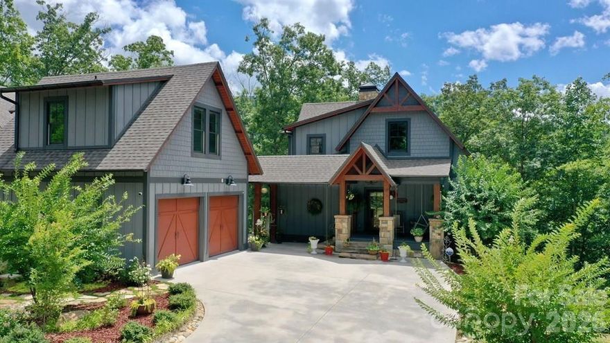 Perched in a serene setting above the Tuckaseegee River, known as the North Carolina Trout Capital, this property offers quiet luxury and rustic charm amongst a backdrop of soft textures, aged woods and rooms designed to slow life down. The home features 2 master suites, one on the main level and one in the walkout basement. Both have windows facing the river. A separate garage apartment provides flexible options: ideal for long-term rentals, a private office/studio or guest accommodations. The property includes a double detached garage for ample storage and convenience. Surrounded by mature, meticulously maintained landscaping, it is a gardeners paradise, complete with terraced beds and a wide assortment of plantings. Enjoy mountain views from the front porch swing and tranquil river vistas in the back, creating a balance of scenic splendor. The enclosed, heated sunroom offers year-round relaxation, bathed in natural light. With its blend of elegant design, practical amenities and idyllic setting, this home is a rare find for those seeking a peaceful retreat with modern comforts.