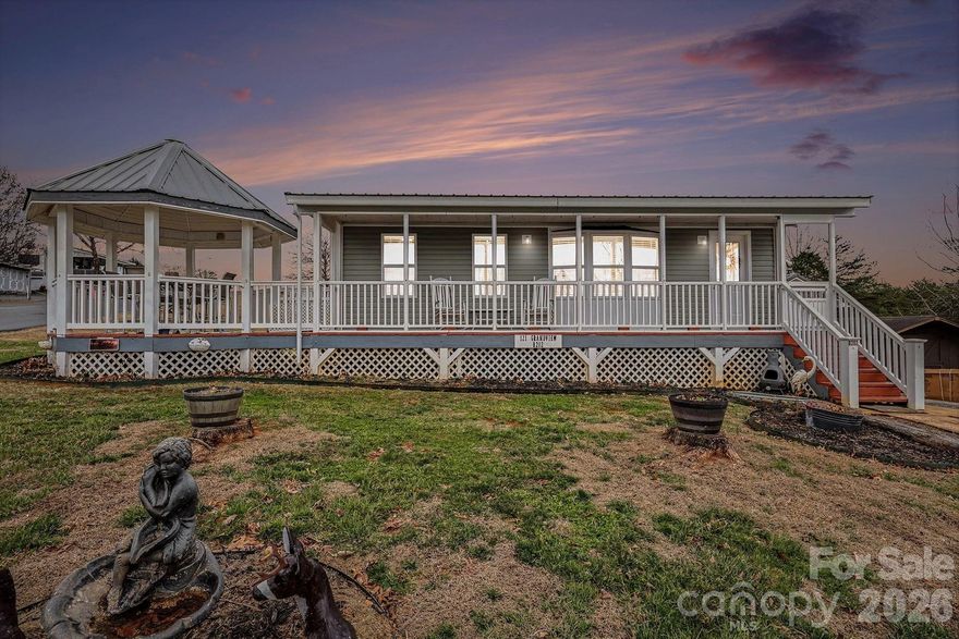 Water views, updates, storage, expansion potential, and outdoor living spaces—everything you could possibly be looking for is right here! Enjoy morning coffee in the gazebo while taking in the beautiful water views. The spacious corner lot has abundant parking, a fenced backyard, and two storage buildings. You will appreciate the many recent updates, including a metal roof, updated siding and windows (park model) new exterior doors, and a freshly painted neutral interior ready for your personal touches. The remodeled kitchen features stainless appliances, modern cabinetry, tile backsplash and updated flooring throughout. The bath has been updated with a step-in shower and a convenient stacked washer/dryer installed on the main level.  Downstairs, the partially finished walk-out basement offers incredible storage, and expansion possibilities with plumbing already in place—ideal for adding additional living space. Out back, enjoy the covered porch or lower level covered patio.