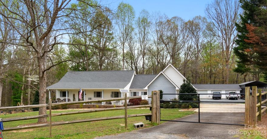 Beautiful country style 3 bedroom, 2 bath farmhouse that sits on 1.83 acres! Located in Indian Land the large, covered porch welcomes you into a charming open split floorplan beginning with the dining room and living room that are warm & inviting. The kitchen boasts granite countertops, tiled backsplash, SS appliances and a large open farmhouse sink. The newly installed top of the line LVF covers the floor as it extends into the hallway where you'll find a full bath and two large bedrooms. Across the house you will find the primary bedroom with a full bath, dual vanity and a large walk-in closet. All bedrooms have new, high-quality carpeting. If all of that wasn't enough, the property provides true country living w/ a completely fenced yard with solar gate, heated, cooled, & plumbed detached 3 car garage (28'x40'x8').  RV carport (40'x18'x12'), above ground pool w/surround deck (24' across), security system, garden, two sheds (one wired) with lean-to and a fenced in area.