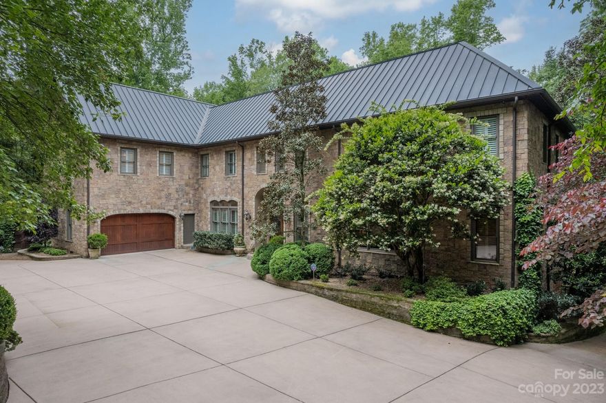 Absolutely STUNNING full stone home with copper roof & over 10,000 sq. feet of living space located just off Providence Rd. near Raintree Country Club. To see the true beauty, WATCH the VIRTUAL TOUR! This incredible property is tucked away from congestion in a true wildlife sanctuary. Enjoy the serenity on the multiple covered patio areas and porches. Backyard area has pristine landscaping, in-ground pool (re-plastered 2021), and tons of space for hosting! Highlights of the home include a breathtaking library with spiral staircase to second floor loft, grand living room with rich wooden built-in's open to a true gourmet chef's kitchen. Open flow throughout plus distributed audio and tasteful gallery art display's. Primary bedroom w/ incredible ensuite - like living a permanent spa retreat. Top floor bonus room has beautiful wooden ceilings and is perfect for game tables / media center. Basement level is partially furnished with options for living quarters and 4 car workshop garage.