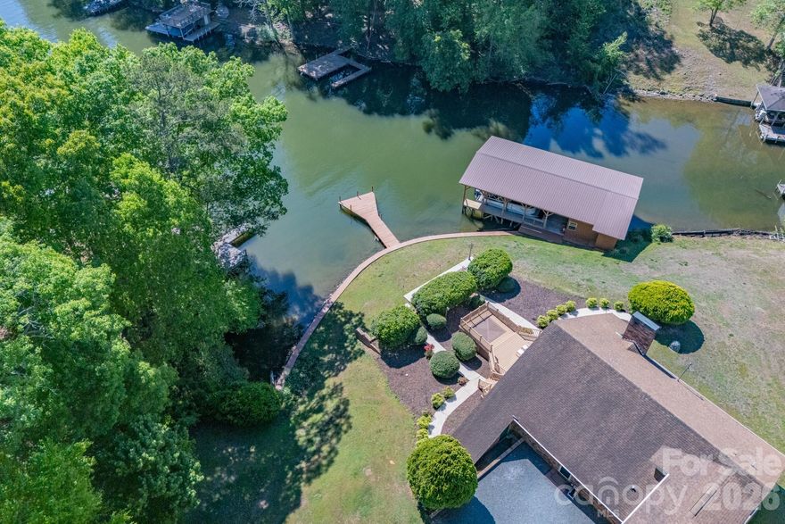 Welcome to River Haven at Lake Tillery—one of the area’s most desirable waterfront communities, where winding roads showcase the natural beauty of the Uwharrie foothills. Nestled on a spacious, gently sloping lot, this property offers both privacy and an easy approach to the water’s edge.
This charming A-frame home is designed to maximize its stunning lake views, featuring a dramatic floor-to-ceiling wall of glass that fills the interior with natural light and opens to an expansive waterside deck—perfect for relaxing or entertaining. The deck is already wired for a hot tub, creating an ideal outdoor retreat.
Inside, the great room boasts a striking stone fireplace with gas logs, creating a warm and inviting focal point. The open kitchen overlooks the great room, making it easy to host and stay connected with guests.
The lower level includes a spacious primary bedroom with a walk-in closet, a convenient laundry area, and a guest bedroom—perfect for hosting family and friends. Upstairs, a loft overlooks the great room and offers beautiful views of the lake. A later addition enhances the home with a generous recreation room featuring French doors and a full bath—perfect as a second primary suite, guest quarters, or flexible living space.
Completing the property is a two-slip boathouse with an oversized storage area, ideal for all your lake gear and watercraft.
Just bring your decorator’s touch to make this home your own and enjoy lake living at its finest—peaceful, private, and designed for making lasting memories.