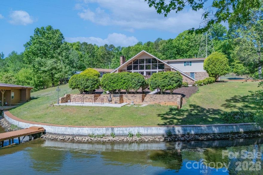 Welcome to River Haven at Lake Tillery—one of the area’s most desirable waterfront communities, where winding roads showcase the natural beauty of the Uwharrie foothills. Nestled on a spacious, gently sloping lot, this property offers both privacy and an easy approach to the water’s edge.
This charming A-frame home is designed to maximize its stunning lake views, featuring a dramatic floor-to-ceiling wall of glass that fills the interior with natural light and opens to an expansive waterside deck—perfect for relaxing or entertaining. The deck is already wired for a hot tub, creating an ideal outdoor retreat.
Inside, the great room boasts a striking stone fireplace with gas logs, creating a warm and inviting focal point. The open kitchen overlooks the great room, making it easy to host and stay connected with guests.
The lower level includes a spacious primary bedroom with a walk-in closet, a convenient laundry area, and a guest bedroom—perfect for hosting family and friends. Upstairs, a loft overlooks the great room and offers beautiful views of the lake. A later addition enhances the home with a generous recreation room featuring French doors and a full bath—perfect as a second primary suite, guest quarters, or flexible living space.
Completing the property is a two-slip boathouse with an oversized storage area, ideal for all your lake gear and watercraft.
Just bring your decorator’s touch to make this home your own and enjoy lake living at its finest—peaceful, private, and designed for making lasting memories.