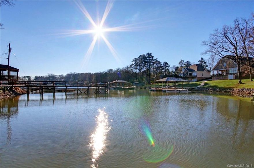 Waterfront cottage or weekender for everyone to enjoy.  All brick with screened porch to enjoy the summer days & nights.  Open concept with laminate flooring in living area.  Brick wood burning fireplace.  Gas pac is 10 yrs old.  Metal Roof.  Quiet cove with covered boatslip and year round water.