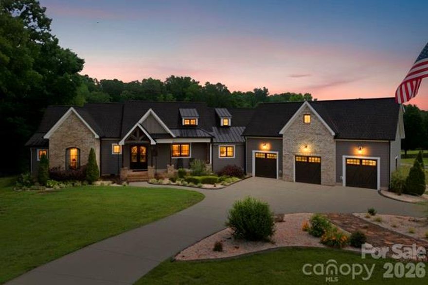 Welcome to a one-of-a-kind custom home where modern luxury, thoughtful design, and income-producing potential come together seamlessly. Built in 2020, this stunning property was designed for both elevated everyday living and unforgettable entertaining.
As you enter the home, the foyer immediately sets the tone with curated art display walls accented by dedicated lighting, creating a true gallery-style entrance. Rich black walnut hardwood floors run throughout the home, complementing the open-concept main living area that combines the living room, dining space, and chef’s kitchen into one expansive and inviting gathering space. The kitchen features luxury Dacor appliances, abundant workspace, and upscale finishes throughout. Anchoring the living room is a dramatic 60” direct vent linear stone fireplace with reclaimed hand-hewn beam mantle and custom built-ins.

Massive 12’ sliding doors open to nearly 1,000 square feet of composite decking, extending the living space outdoors and creating the ultimate entertainment area. Built-in surround sound speakers inside and out, home automation capabilities, dimmable smart switches, and whole-home mesh WiFi wiring elevate the home’s modern functionality.

The primary suite on the main floor is a true retreat featuring heated tile floors, elegant crown lighting, oversized walk-in closet systems with adjustable custom shelving and shoe storage, plus a hidden concealed storage space. The spa-inspired bath showcases an oversized walk-through rain shower with full body sprayers and luxury finishes throughout.

Two additional oversized bedrooms are also located on the main floor, each with their own private bathroom and spacious custom closets. The laundry room was designed with practicality in mind, offering built-in folding space, additional sink, and direct access to the custom dog wash station before entering the oversized 3-car garage.

Upstairs offers flexible finished living space perfect for work, play, or guests. A large built-in office area provides an ideal workspace, while the loft overlooks the living room through a stunning custom 3D metal railing design. The soaring ceilings create enough vertical space for an impressive 17’ Christmas tree centerpiece during the holidays. An additional upstairs room, currently used as a playroom, connects to a full bathroom and guest suite tucked quietly away for ultimate privacy.

Adding even more value, the detached studio apartment above the garage offers approximately 1,000 square feet of additional living space and incredible income-producing potential. Thoughtfully designed with separation and privacy in mind, the guest suite features its own dedicated parking area behind the garage, ensuring privacy for both owners and guests. The spacious studio includes a full kitchen with appliances, open-concept living area, laundry space, full bathroom, and additional nook currently used for extra sleeping accommodations. Whether used as an Airbnb, in-law suite, guest quarters, or private office, this space offers exceptional flexibility and can significantly offset ownership costs.

Additional upgrades and features include authentic 1600s Croatian wine press screws incorporated into the front entry design, on-demand hot water system, irrigation system, prewired exterior security cameras, built-in whole-home speaker system, reclaimed architectural details, expansive storage solutions, and a 3-stage water filtration system.

This is far more than a home — it’s a carefully crafted lifestyle property blending luxury, functionality, character, and opportunity into one unforgettable package