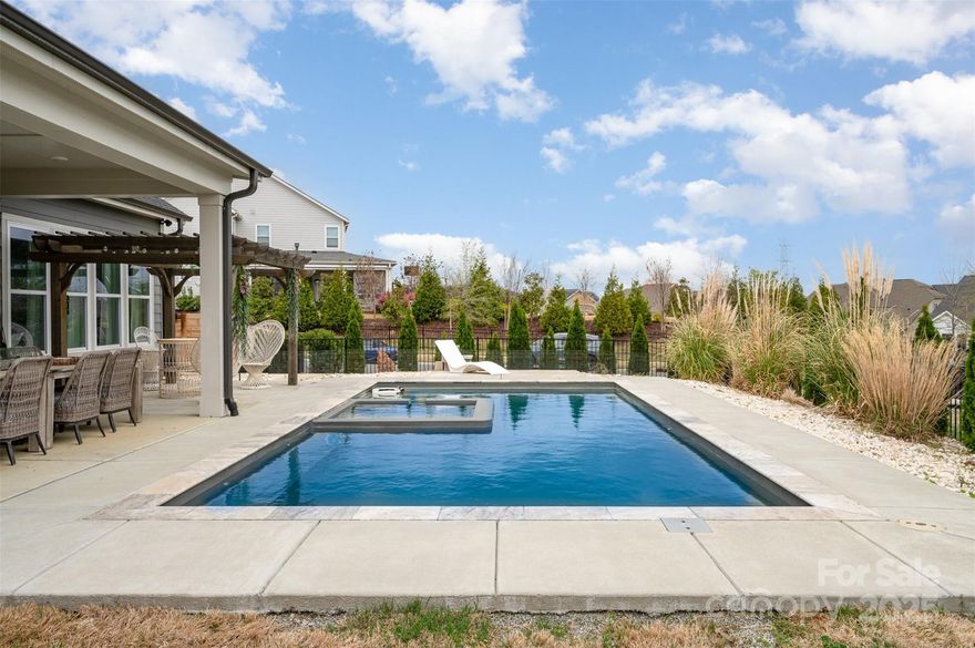 Staycation dreams come true in this stunning 5 bed, 3.5 bath home with nearly 3,500 SF of space designed for comfort and fun. Enjoy a main-floor primary suite plus a second en-suite upstairs—perfect for multi-generational living. A third en-suite bedroom offers added flexibility, while the fifth bedroom is a fully equipped theater room with wet bar, beverage fridge, and in-ceiling surround sound. Step outside to your own private oasis featuring a heated saltwater pool with tanning ledge and in-pool spa, travertine surround, pergola, and two covered patios with built-in speakers. Gas line run to first patio ready for your outdoor kitchen set up. Situated on a private corner lot with lush landscaping, irrigation, and a spacious garage with golf cart/workshop area. 10’ ceilings on main floor complete the picture.  Front roof lines have permanent Christmas lights that can be programmed from phone and synced to music.  Oversized garage ready for a home gym or golf simulator.