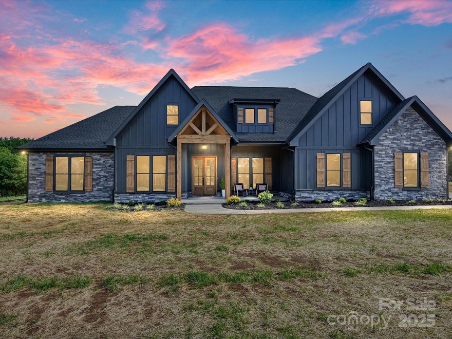 This beautifully crafted, 4-bedroom *plus* a bonus, residence showcases a striking dark exterior w/ rich stone accents & bold wood beams. The vaulted ceilings in the living room & stunning French oak engineered hardwoods enhance the open concept floor plan—perfect for both everyday living & entertaining. The kitchen features quartz countertops w/ gold marble veining, plenty of prep space, & a massive pantry for all your culinary needs. The primary bath offers a lux. retreat w/ stunning black & white tile work, complemented by a massive custom WIC. Enjoy picturesque farm views from your backyard, best experienced from the expansive vaulted back porch w/ tongue-&-groove ceilings & oversized beams—Ample space for your future dream pool! The upstairs bonus w/ full bath provides the perfect space for guests, a home office, or media room. Situated on over 1 acre of peaceful land, you’re just 5 minutes from both downtown York & Clover, & less than half a mile from Springlake Country Club!