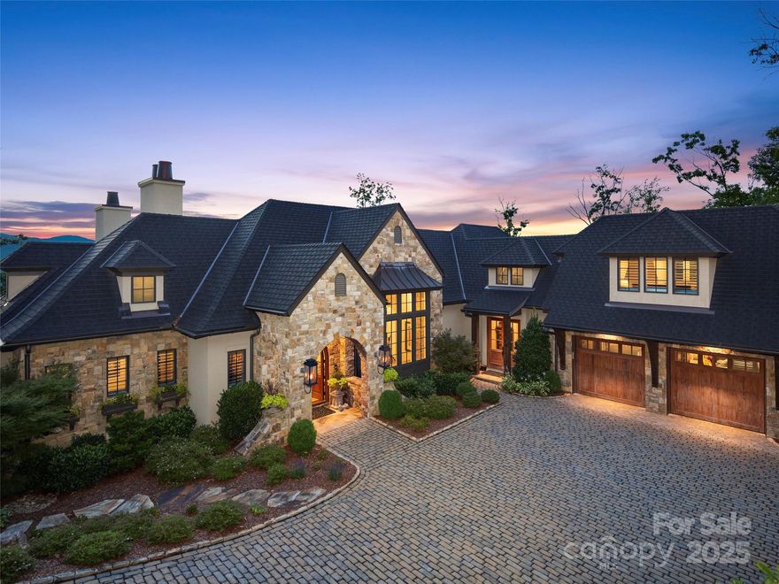Nestled in the prestigious gated community of The Cliffs at Walnut Cove, this magnificent 6,400 sq ft residence, built by the esteemed Dillard-Jones Builders in 2018, is a testament to sophisticated mountain living. With its stunning architecture and meticulous craftsmanship, this home offers a lifestyle of unparalleled luxury, surrounded by the tranquility and awe-inspiring beauty of the Blue Ridge Mountains.
A sanctuary with panoramic views
From the moment you arrive, you are captivated by magnificent, long-range mountain vistas. The home is perfectly positioned to showcase the natural splendor of the surrounding valley and mountains, providing a breathtaking backdrop for everyday life. Whether you're enjoying a quiet morning coffee or hosting an evening soiree, the spectacular views of Walnut Cove are a constant source of inspiration.
Exquisite culinary and entertaining spaces
Designed for the modern epicurean, the chef's kitchen is a masterpiece of both form and function. A massive island serves as the centerpiece, offering a vast workspace for meal preparation and a perfect gathering spot for guests. Beyond the main kitchen, a generous pantry and a dedicated scullery pantry provide abundant storage and prep space, ensuring the main area remains pristine for entertaining.
Luxury and convenience on every level
The home’s thoughtful design is centered around convenience and elegant living. With 4 bedrooms, 4 full bathrooms, and two powder rooms, there is ample space and privacy for all. An elevator effortlessly connects the home’s levels, providing ease of access for both residents and guests. For the ultimate work-from-home experience, an office provides a dedicated, sunlit space with inspiring long-range mountain views.
Resort-style amenities
Step downstairs to discover a world of entertainment. The lower level features a sophisticated wine room, perfect for the avid collector, and a stylish bar area complete with an ice maker and a beer tap, ready for any celebration. This level extends to a lower patio, an outdoor oasis where you can unwind by the warmth of a fireplace or soak your cares away in the hot tub. The outdoor space is further enhanced by a tranquil water feature and a fire pit, creating a serene ambiance for relaxation.
Bonus room and guest retreat
The luxury continues with a versatile bonus room located over the garage. This private suite is equipped with a full bathroom and a morning kitchen, offering the ideal retreat for guests, an au pair, or an in-law suite.
This exceptional Dillard-Jones build offers an extraordinary combination of sophisticated design, high-end amenities, and a breathtaking mountain setting. Experience a refined lifestyle in one of Asheville's most sought-after communities, where every detail has been meticulously crafted for your comfort and enjoyment..