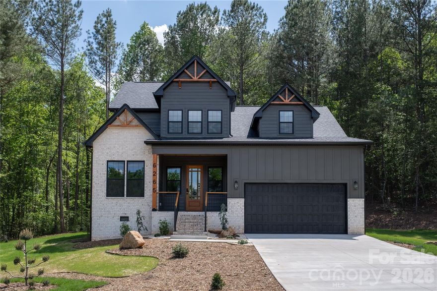 No city taxes or HOA! This rare 1.6-acre property offers exceptional privacy in a scenic wooded setting with partial lake views. Thoughtfully designed with high-end Forno appliances, custom trim and moldings, Bluetooth bath fans, 4" plank oak hardwood, and integrated soffit lighting outlets. The open floor plan boasts soaring ceilings, a spacious custom drop zone, and a full laundry room with quartz-topped utility sink. The luxurious primary suite features a tiled glass shower and custom built-in walk-in closet. Enjoy the large deck and fire pit at the adjacent lower patio area; perfect for entertaining or peaceful evenings outdoors. Professionally designed landscaping frames the home with natural beauty and space to garden or play. Plus, there’s an additional 200 sq ft of walk-in attic space ready to finish for future expansion. All this with a reasonable commute to the Charlotte and Triad metro areas, and a quick drive to Boone, offering modern luxury, privacy, and space to grow.