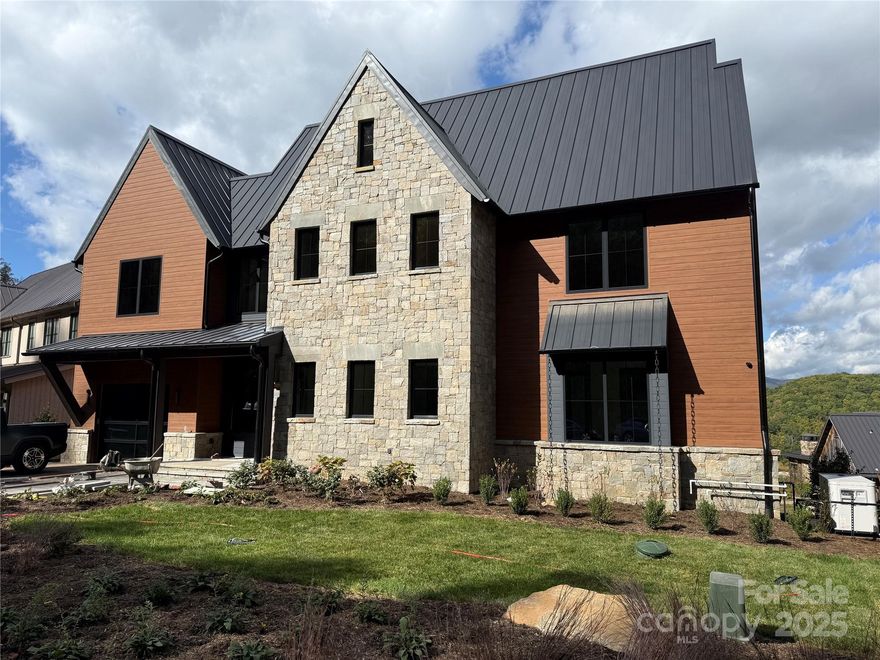 Experience mountain living at its finest in this exquisite home perched in the coveted Doubletop Village, where sweeping long-range mountain views meet unmatched craftsmanship and modern comfort.
Every detail of this residence reflects thoughtful design and quality — from the custom walnut cabinetry throughout to the seamless blend of natural textures and sophisticated finishes. The open-concept living spaces are warm and inviting, perfect for quiet mornings or lively gatherings with family and friends.
The gourmet kitchen is a true showpiece, featuring premium appliances, rich walnut cabinetry, and a large island that anchors the heart of the home. Step outside to the outdoor kitchen and expansive deck, where you can entertain, dine al fresco, or simply take in the ever-changing mountain scenery.
When it’s time to unwind, retreat to the private theater room for movie nights, browse your collection in the beautifully finished wine cellar, or relax in the serene primary suite with spa-inspired finishes. Thoughtfully designed with abundant storage throughout, this home includes every upgrade imaginable — from designer lighting and high-end fixtures to a whole-house generator ensuring comfort and peace of mind in every season.
Located within walking distance to the club, this home offers both convenience and a deep connection to the Doubletop community. Whether as a year-round residence or mountain escape, this property embodies the perfect balance of luxury, tranquility, and natural beauty.

Balsam Mountain Preserve is a private 4,400 acre club community with 3,200 acres of conservation land and completed amenities featuring golf, equestrian, scenic trails, tennis and dining. The stunning new facilities at Doubletop Village, including the Summit House Restaurant and Mine Tavern, are now open to members and their guests.