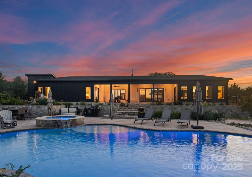 Discover unparalleled privacy and luxury in this stunning custom-built modern estate, completed in 2023 set on 34.1 acres. This luxury property offers the perfect blend of high-end living and functional farm life. The main home features an open-concept layout with vaulted ceilings, interior courtyard, Gyrofocus suspended fireplace, and polished concrete floors throughout. The gourmet kitchen is a chef's dream with dual islands, 10-burner range, pantry, and premium appliances. Spacious primary suite, 3 guest bedrooms, a bonus/flex room, and oversized 3-car garage. Outdoor living includes a 23,000-gallon saltwater pool, travertine pool deck, and a covered outdoor dining area. A separate 2BR guest cottage with full kitchen, hot tub, and private patio offers guest space or rental potential. Property includes multiple barns, fenced pastures, fruit trees, private trails, spring water, 2 wells, and whole-house water filtration. No HOA. Endless possibilities—farm, retreat, or private estate!