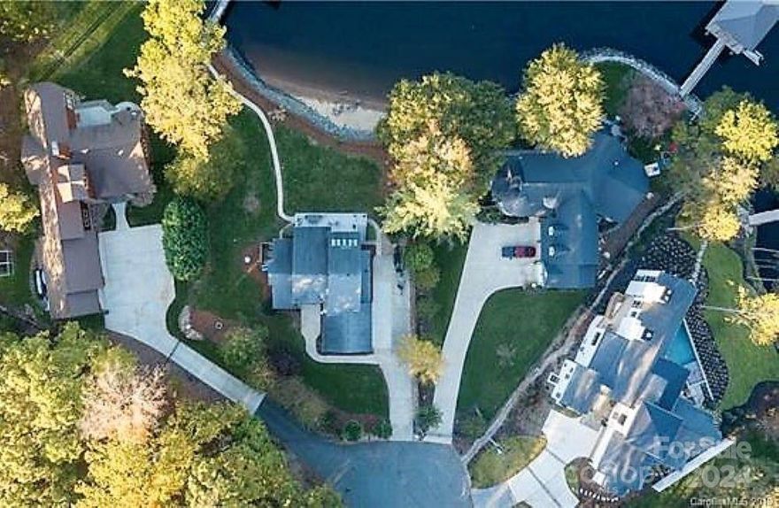 Location! Location! Location!   Big Water Views! Located on a a quiet street with no HOA.  Large level lot with room for expansion. Easy Commute to Charlotte via 16 or 77.  Birkdale shopping close by.  Fantastic "one of a kind" sandy beach.  Nice stationary dock with covered boat slip with lift.  The home has brand new decking 2023,  A new HVAC 2022, New bathroom added 2023, Connected to city water and sewer 2021.  Large upgraded kitchen with high end appliances, large granite island & enormous pantry.  No carpet anywhere.  2 Built in drop zones. Updated lighting through-out home.  Bathrooms updated in 2023.  Separate private guest suite created in 2023 with its own private bath.  Primary Suite features big views, a sitting area, a private bath and his and hers closets. 2 car garage currently is used as a game room.  Outdoors is a playground for kayaking, boating, swimming, & fishing.  Relax on the lower level in the lakeside hot tub.  The sunrises are spectacular.